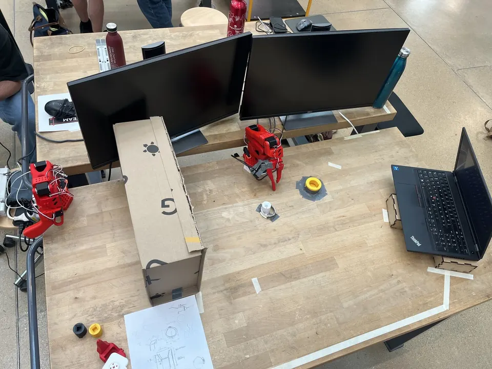 Workspace setup with the SO-101 robot arm, custom gripper, and peg/keyhole on the table